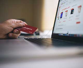 holding credit card using laptop